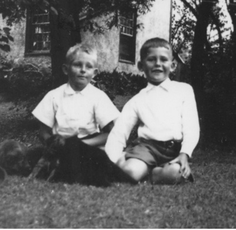 Vintage photo of two young boys sitting on grass